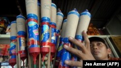 Seorang pekerja menawarkan kembang api di sebuah toko di Kota Bocaue, Provinsi Bulacan, Filipina, 29 Desember 2008. (Foto: Jes Aznar/AFP, arsip)