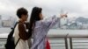 两名中国年轻人五一节前到香港游玩时在小红书上寻找旅游攻略。（2024年4月30日）