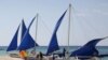 FILE - Tourists takes photographs along local sailboats on the island of Boracay, central Philippines, Jan. 18, 2016. 
