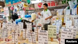 ແຟ້ມຮູບ-ຜູ້ຂາຍຄົນນຶ່ງ ກໍາລັງຊັ່ງນໍ້າໜັກຖົງເຂົ້າ ຢູ່ທີ່ຕະຫຼາດ ໃນໃຈກາງບາງກອກ, ວັນທີ 26 ກໍລະກົດ 2013.