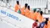 Des migrants et des réfugiés descendent du bateau de sauvetage "Diciotti" en Italie, le 8 janvier 2018. AFP PHOTO / GIOVANNI ISOLINO