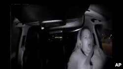 Image made from video, March 18, 2018, of a mounted camera provided by the Tempe Police Department, shows a human backup driver in Uber SUV looking down seconds before it hit a woman in Tempe, Arizona.