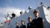 FILE - In this Dec. 7, 2016, photo, Chinese Navy officials stand in front of the ship Daqing, in San Diego.