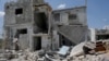 Les membres de la famille de Saher al-Ali se tiennent à l'intérieur de leur maison endommagée dans la ville de Nairab, tenue par les rebelles, dans la région d'Idlib, en Syrie, le 17 avril 2020.