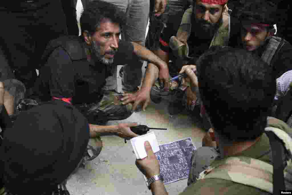 Free Syrian Army fighters get briefed prior to an offensive against forces loyal to Syria's President Bashar al-Assad, in Aleppo's Salaheddine neighborhood, July 6, 2013.