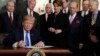 President Donald Trump signs a presidential memorandum imposing tariffs and investment restrictions on China in the Diplomatic Reception Room of the White House, March 22, 2018.