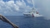 FILE - A Chinese Coast Guard vessel approaches a Filipino fishing boat off Scarborough Shoal in the South China Sea, Sept. 23, 2015.